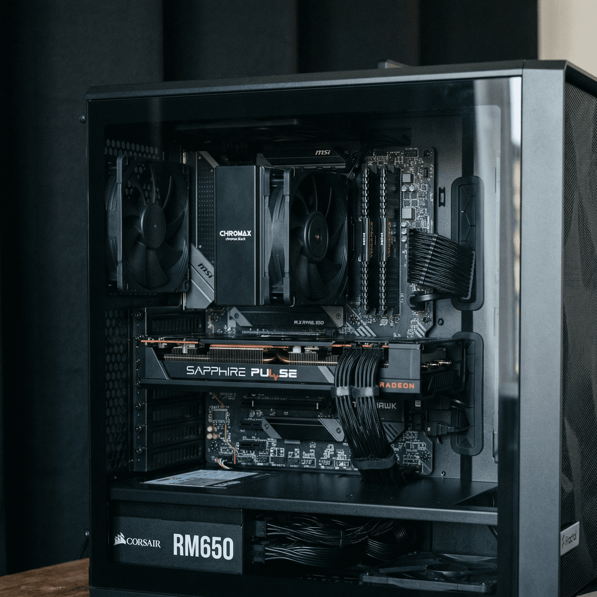 Mid-range gaming PC inside an ATX tower with a side-panel window, RX 6600 XT visible, two case fans, clean build, RGB off